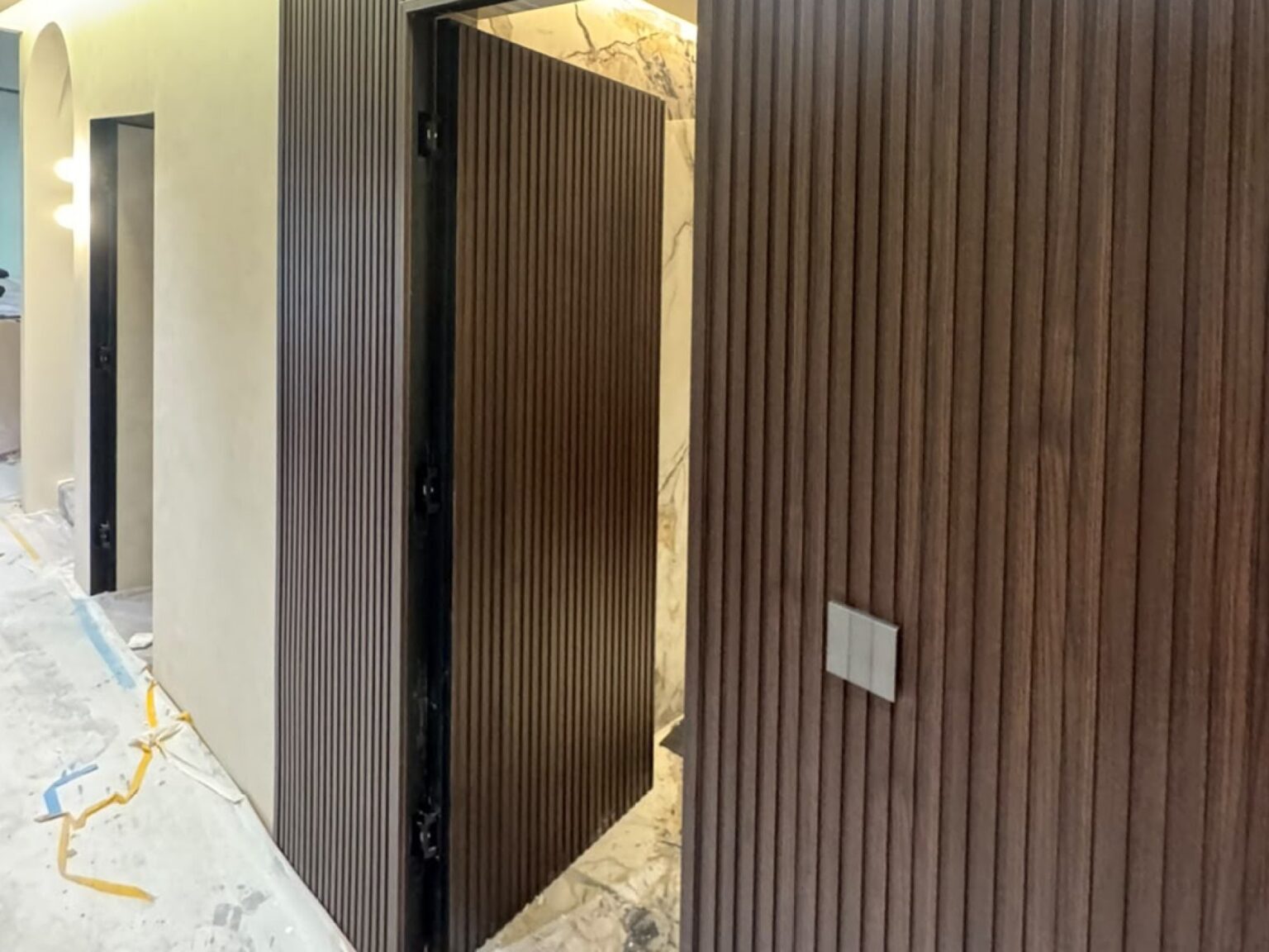 Fluted panel corridor wall with a flush concealed door