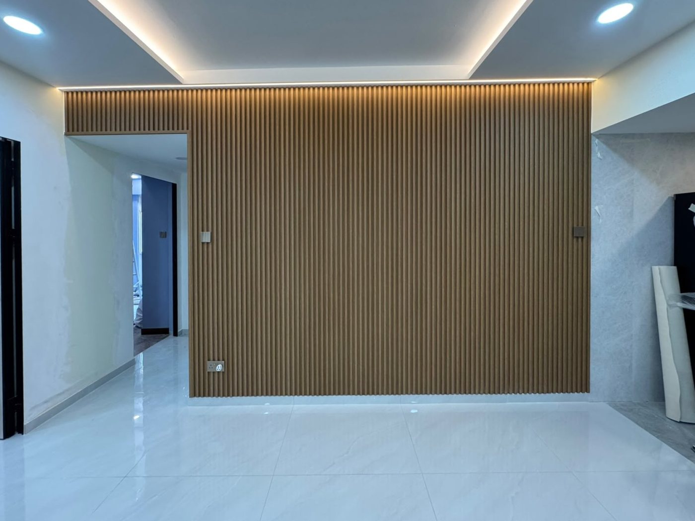 Wood-look fluted panel feature wall with LED cove lighting, installed by Wood Origins